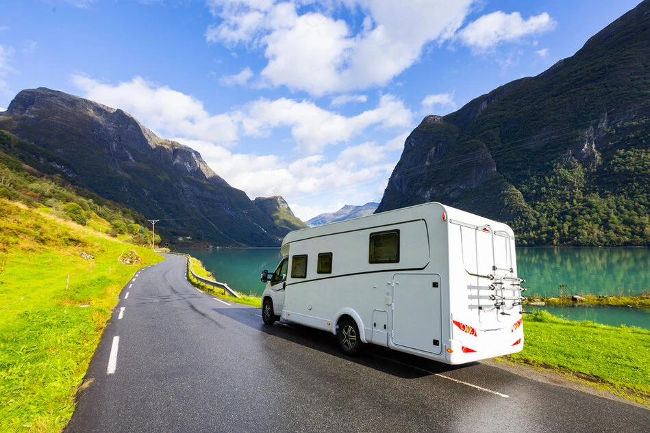 Paar steht vor einem Wohnmobil und plant die erste Reise